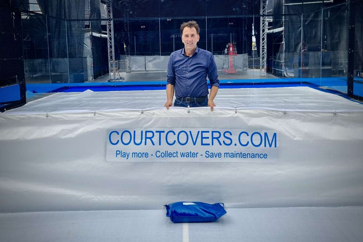 Man showing a fully covered Padel court with the Courtcovers.com protection system and the slogan ‘Play more, collect water and save maintenance.’